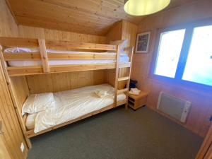 a bedroom with two bunk beds in a cabin at Chalet Le Jeuna in Morgins