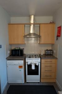 a kitchen with a stove and a microwave at 1BR Charming Cottage in Central Moffat in Moffat