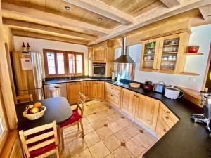 a kitchen with wooden cabinets and a table with a bowl of fruit at Le Mélézin Bleu in Morgins
