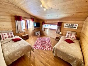 a bedroom with two beds in a log cabin at Le Mélézin Bleu in Morgins