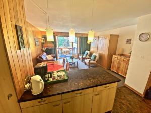 a kitchen with a counter top and a living room at 4 person apartment in central location in Morgins +3 photos