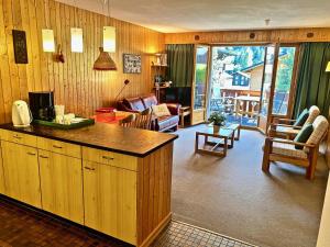 a kitchen and living room with a view of a living room at 4 person apartment in central location in Morgins