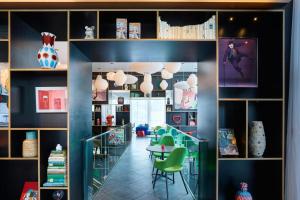 a dining room with a table and green chairs at citizenM Paris La Défense in Nanterre