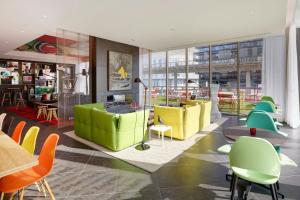 a lobby with colorful chairs and tables in a building at citizenM Paris La Défense in Nanterre +29 photos