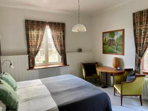 a bedroom with a bed and a table and two windows at THE LODGE Torsby in Torsby +20 photos