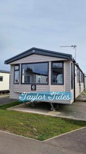 a tiny house parked in a parking lot at Taylor Tides Caravan in Abergele