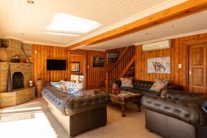 a living room with leather couches and a fireplace at Addo Nyala Guest Lodge in Paterson