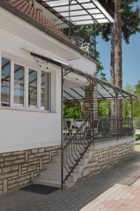 a porch of a house with a railing and stairs at Müller's 1 in Siófok