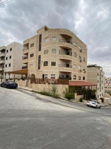 a large building with cars parked in front of it at الوليد للشقق المفروشة in Amman