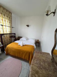 a bedroom with a bed with a yellow blanket at Lilas house in Les Lilas