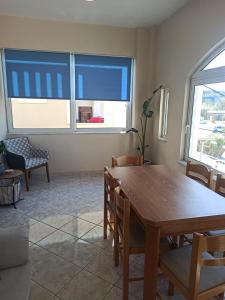 a dining room with a table and chairs and two windows at Panos Apartment in Almyrida