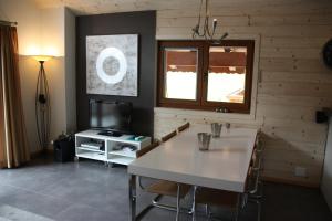 a living room with a table and a television at Edelweiss B31 in Morgins