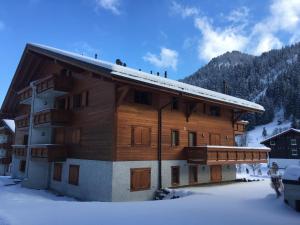 a large wooden building with snow on the roof at Edelweiss B31 in Morgins +8 photos