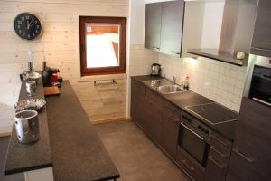 a kitchen with a sink and a clock on the wall at Edelweiss B31 in Morgins