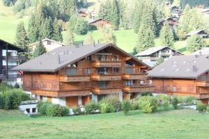 a large wooden house in the mountains with trees at Edelweiss B31 in Morgins
