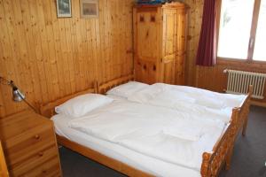 ein Schlafzimmer mit einem großen Bett mit weißer Bettwäsche in der Unterkunft Pre Vert 44 in Morgins
