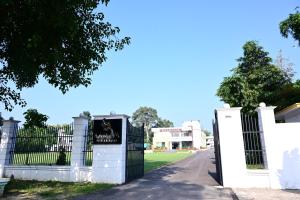 a white fence with a gate in front of a field at Ramaya Hotel & Banquet in Sidhaulī