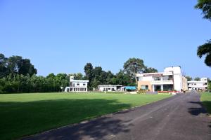 a large grass field with buildings in the background at Ramaya Hotel & Banquet in Sidhaulī
