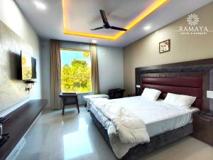 a bedroom with a large bed with a ceiling fan at Ramaya Hotel & Banquet in Sidhaulī