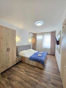 a bedroom with a bed and a wooden floor at Hotel Arbëri Events in Rahovec