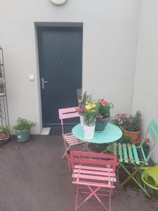 a table with two chairs and a table with potted plants at Coutances in Coutances +2 photos