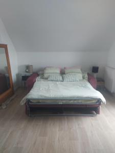 a bed in a room with a wooden floor at Coutances in Coutances