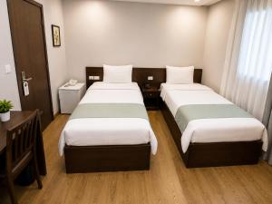 a hotel room with two beds and a desk at Elysees Hotel I Tahrir Square in Cairo