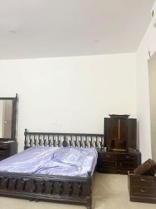 a bedroom with a bed and a dresser and a television at Solace in Coimbatore