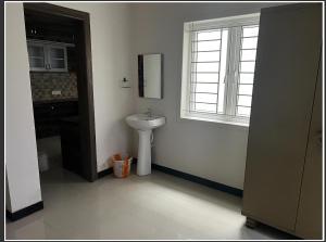 a bathroom with a sink and a window at Solace in Coimbatore +1 photo