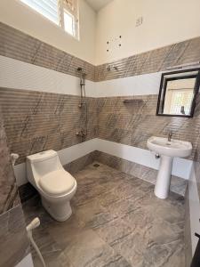 a bathroom with a toilet and a sink at Solace in Coimbatore