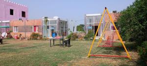 a swing set in a yard with buildings at Hotel krishna manu place in Orchha