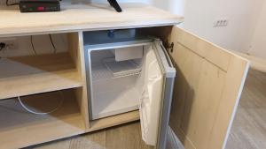 an open refrigerator in a kitchen under a counter at Pensiunea NEST in Dunavăţu de Jos