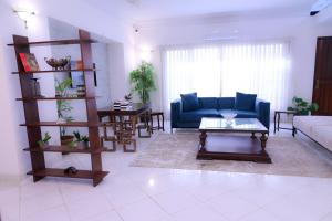 a living room with a blue couch and a table at Elevé Stays - Boutique Family Suites in Karachi +25 photos