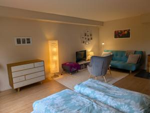 a living room with a blue couch and a chair at Ferienwohnung am Waldrand, Hitzacker in Hitzacker