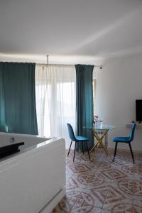 a living room with blue chairs and a table and a window at Firmamento Royal House in Rocca Priora