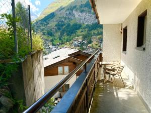 a balcony with chairs and a view of a mountain at Hotel Alpenroyal in Zermatt