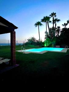 a swimming pool with palm trees and a playground at Exclusive Beachfront Penthouse in Almayate Alto