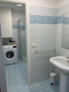 ein Badezimmer mit Waschmaschine und Waschbecken in der Unterkunft viamarsala in Iesi