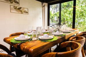 a long wooden table with plates and glasses on it at Uno Maya by Araw Residences in Nasugbu