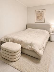 a white bedroom with a bed and a stool at Coco Villa Sinsa in Seoul +4 photos