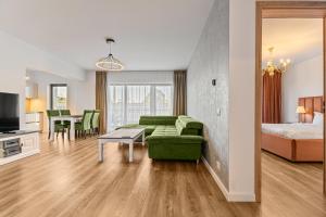 a living room with a green couch and a bedroom at KOA - Aparthotel in Braşov