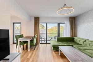 a living room with a green couch and a table at KOA - Aparthotel in Braşov