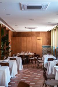 a restaurant with tables and chairs with white table cloth at Hotel Casa de la Torrecilla in Campo de Criptana