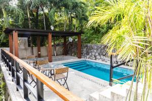a swimming pool with tables and chairs next to a house at Uno Maya by Araw Residences in Nasugbu