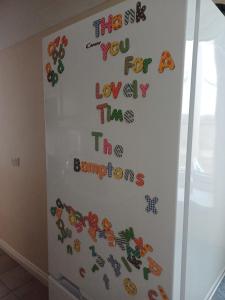 a white refrigerator with alphabet magnets on it at Large countryside home in Tow Law