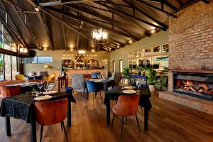 a restaurant with tables and chairs and a fireplace at Dunkeld East in Dullstroom