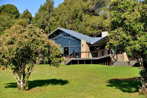 a house in the middle of a field with trees at Dunkeld East in Dullstroom