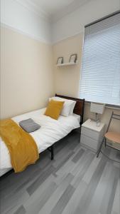 a bedroom with a large bed and a chair at Stirling Steet in Wallasey