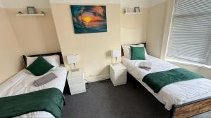 two beds in a room with green and white at Stirling Steet in Wallasey +35 photos
