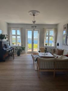 a living room with a couch and a table at Bondegård med havudsigt in Kolding